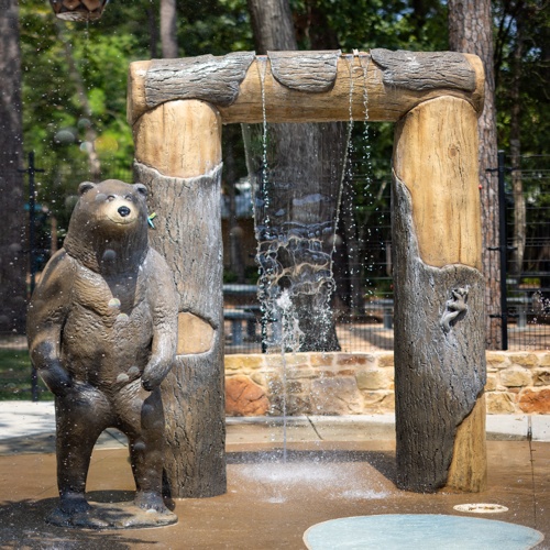 a GFRC bear and archway at a splash pad