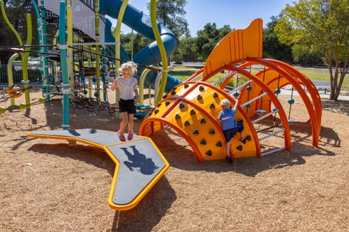 An orange custom fish climber with children playing