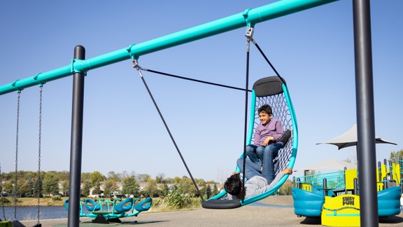 Boys playing on Flexx Swing, inclusive cable net swing from Landscape Structures